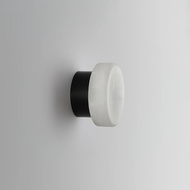 Side view of cylindrical alabaster wall light with black wall mount for stylish home décor
