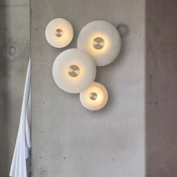 Disc-shaped alabaster wall light lamps in four sizes, wall view, elegant modern interior lighting