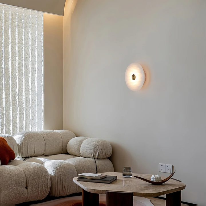 Disc-shaped alabaster wall light, living room view, elegant modern interior wall lighting
