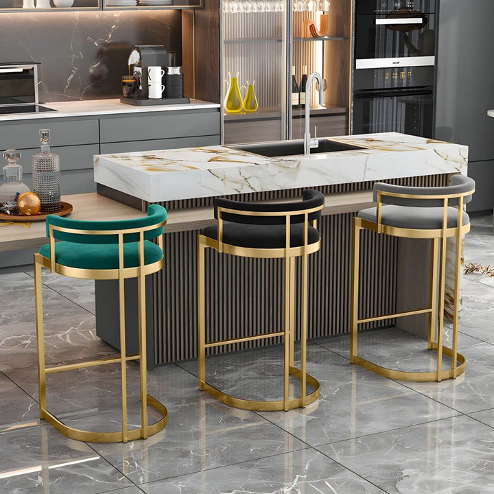 Glam bucket upholstered bar stool with gold metal base – angled view showcasing plush seating and elegant metallic finish.