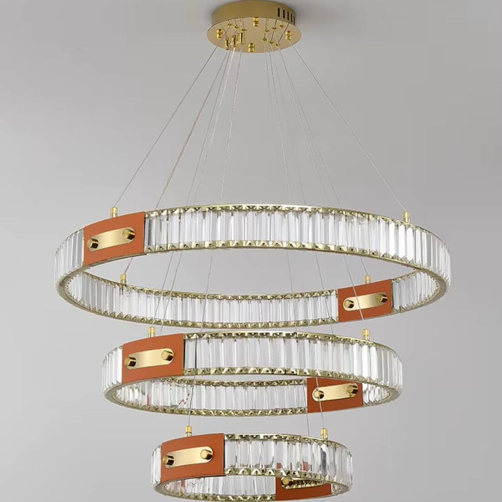 Close front view of gold crystal chandelier with three interlocking rings, showcasing sparkling crystals and elegant design