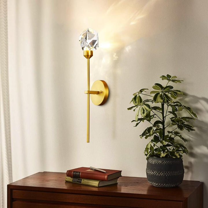 Harmony indoor crystal wall sconce mounted above dining table, featuring elegant gold finish and shimmering crystal design for ambient lighting
