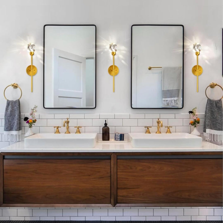 Harmony indoor crystal wall sconce with gold accents and crystal detailing, installed beside washroom mirror for elegant vanity lighting