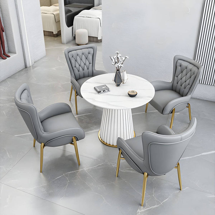 et of four Henry dining chairs with customizable leather or velvet upholstery and metal legs around a round dining table – modern and elegant dining setup.