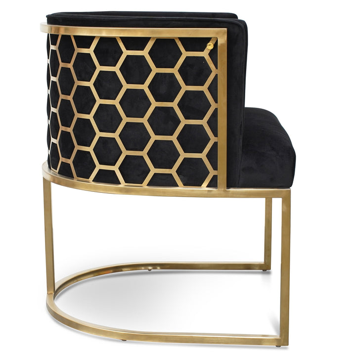 Side view of Kate lounge chair in black velvet with brushed gold armrests and blue steel sofa core – luxurious and modern interior design