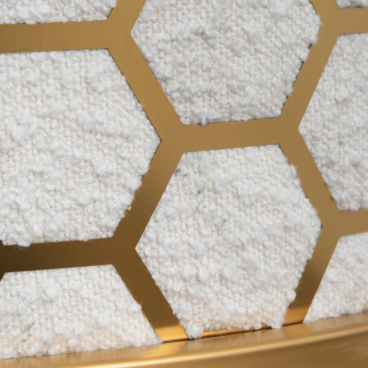 Detail view of Kate white velvet lounge chair with black velvet seat, brushed gold armrests, and blue steel sofa core – close-up of steel frame showcasing sleek, polished craftsmanship