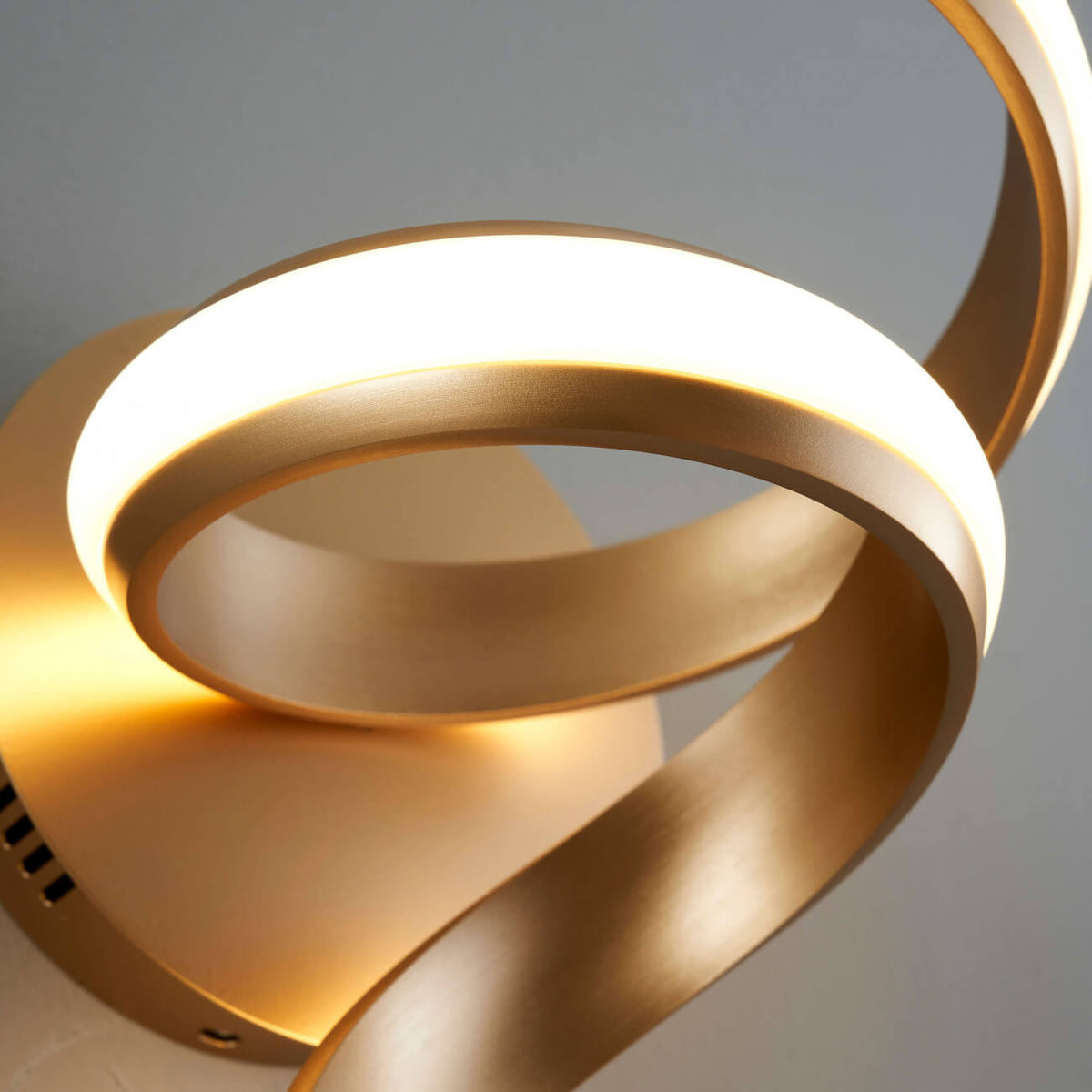 Close-up detail of Lara golden spiral LED wall sconce light by Lux Decor Australia