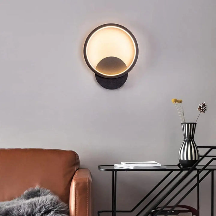 Front view of Lumen Ring wall light in a modern living room, adding soft ambient circular lighting.