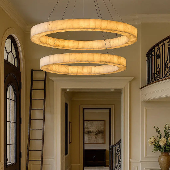 Modern chandelier hanging in a well-lit hallway with a decorative ladder and table.