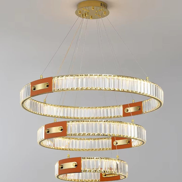 Close front view of gold crystal chandelier with three interlocking rings, showcasing sparkling crystals and elegant design