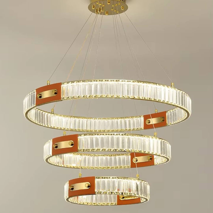 Close front view of gold crystal chandelier with three interlocking rings, showcasing sparkling crystals and elegant design