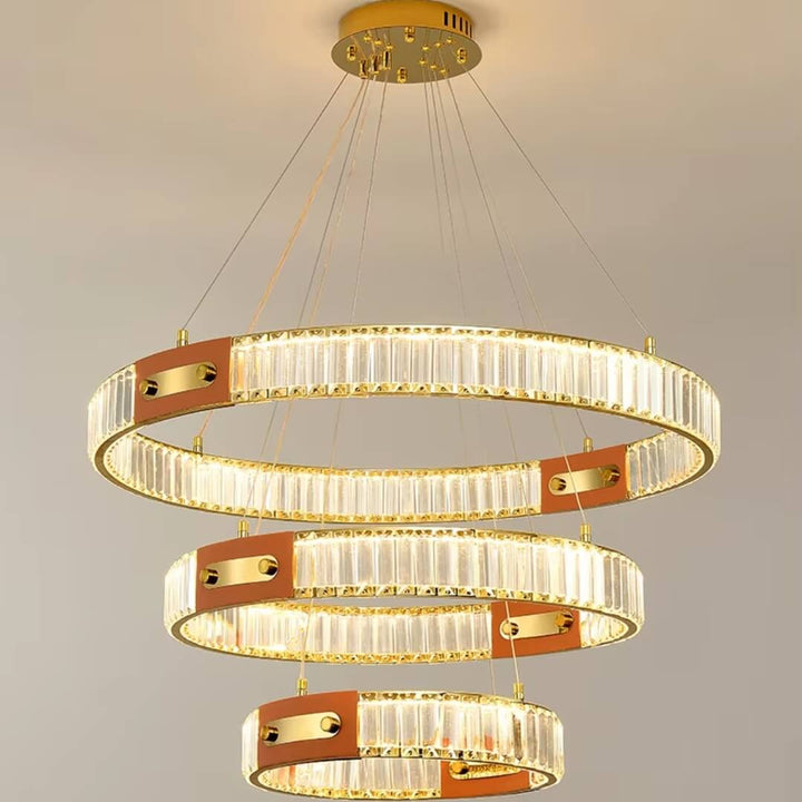 Close front view of gold crystal chandelier with three interlocking rings, showcasing sparkling crystals and elegant design