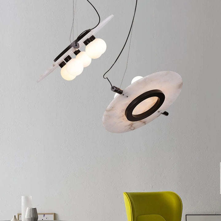 Modern Magma pendant lamp hanging view with black exterior, gold interior, warm glowing light