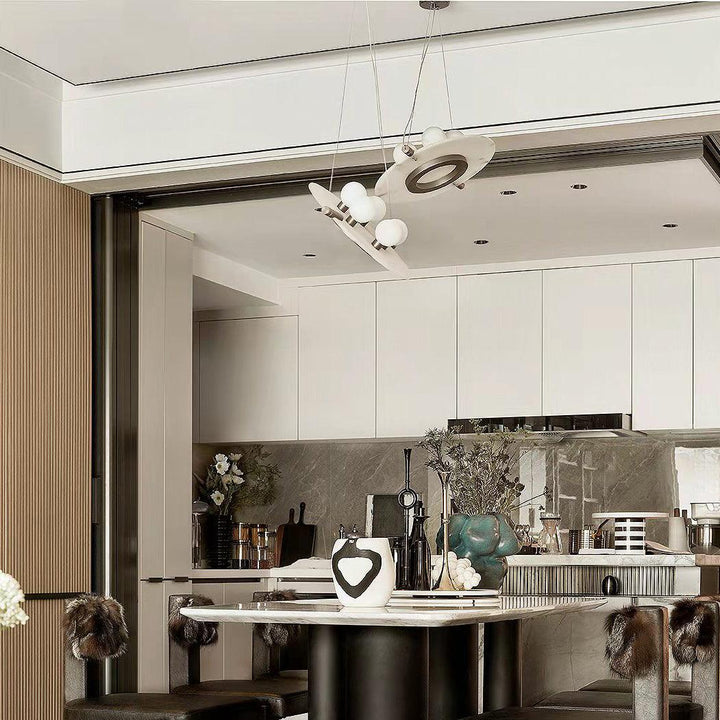 Magma pendant lamp over dining table, black exterior with warm glowing gold interior light