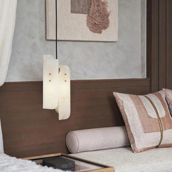 Megalith mini pendant light with modern design, elegantly hanging beside a bed for stylish ambient lighting.