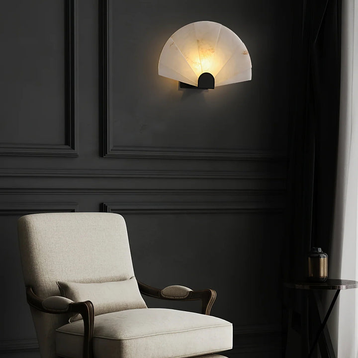 Nevora alabaster wall lamp on living room wall with gold metal accents, modern elegant lighting