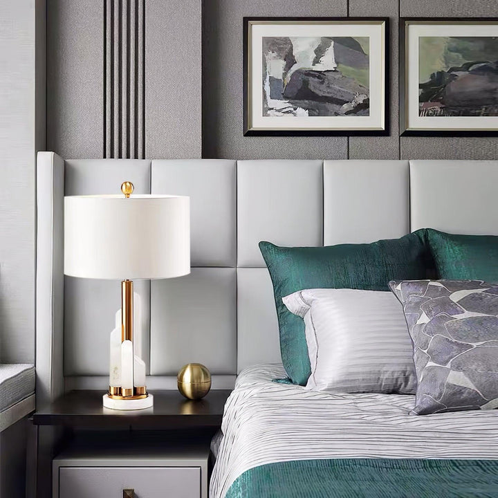 Front bedside view of Orbit metal table lamp with metal shades and marble base, warm LED light
