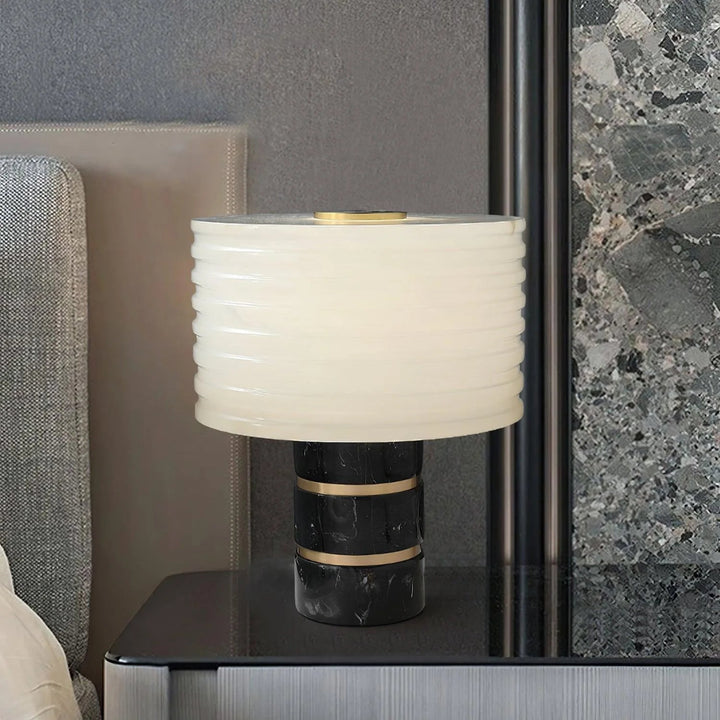 Outela table lamp beside bed, showcasing modern design with warm ambient lighting for cozy interiors
