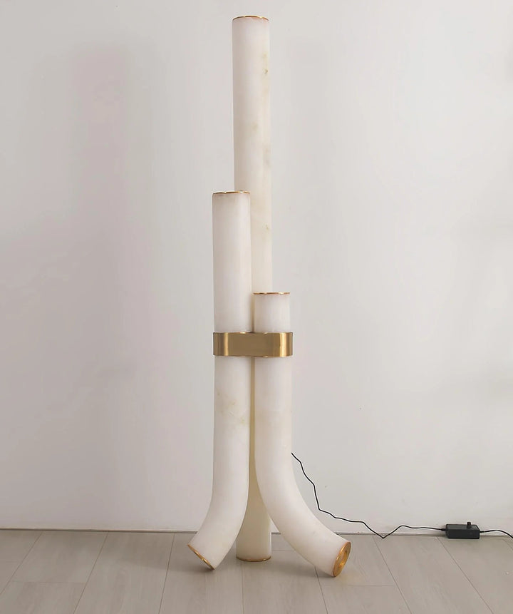 Modern piped alabaster floor lamp with brass accents, offering soft ambient light for contemporary spaces