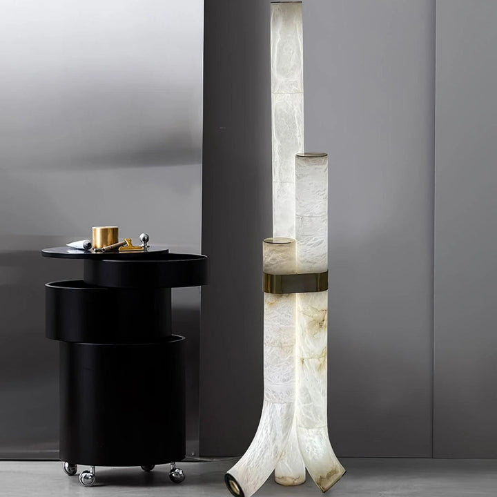 Contemporary piped alabaster floor lamp with brass accents, adding warm modern lighting to interiors