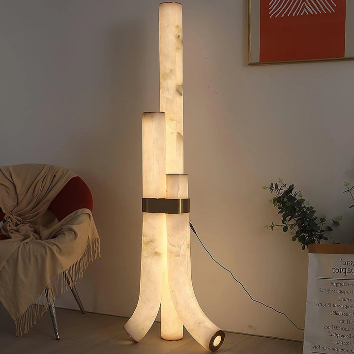 Front view of modern piped alabaster floor lamp, featuring brass accents and soft ambient lighting