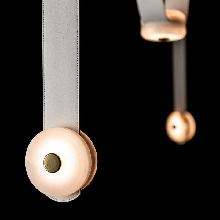 Snaps alabaster pendant light hanging front view with leather details and gold metal accents, elegant design
