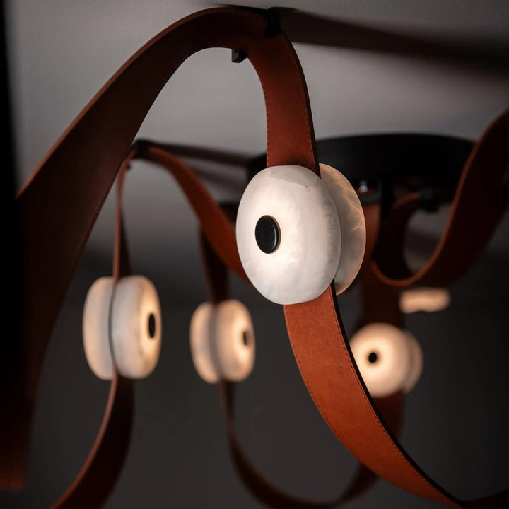 Snaps alabaster pendant light close-up front view showing leather belt and gold metal accents, elegant design