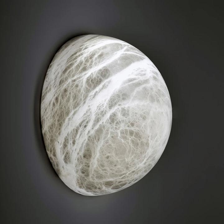 Close side view of Spanish alabaster snowflake wall sconce with light on for home décor