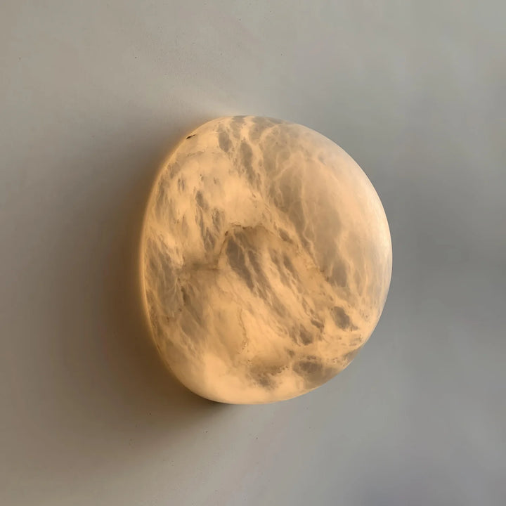 Side view of Spanish alabaster snowflake wall sconce emitting warm light for home décor