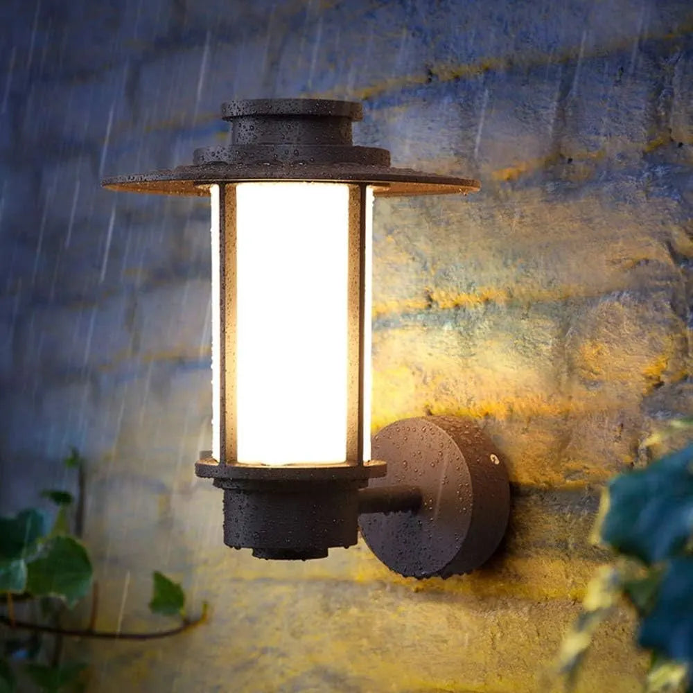STEEL HALO Outdoor Wall Light illuminated in the rain – IP54-rated, weather-resistant design providing warm 3000K lighting in outdoor conditions.