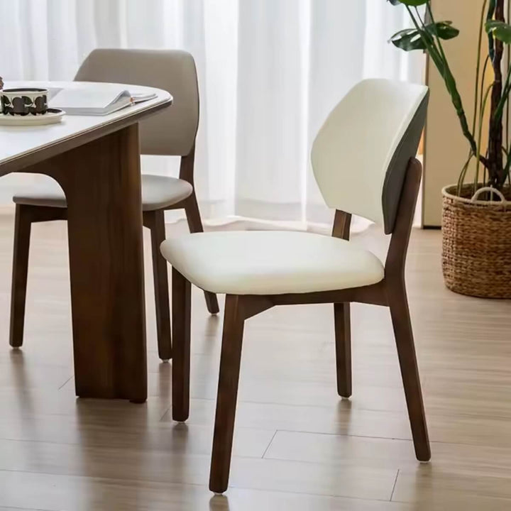 Close-up hero view of Valora walnut dining chair highlighting walnut wood grain and cushioned seat upholstery.