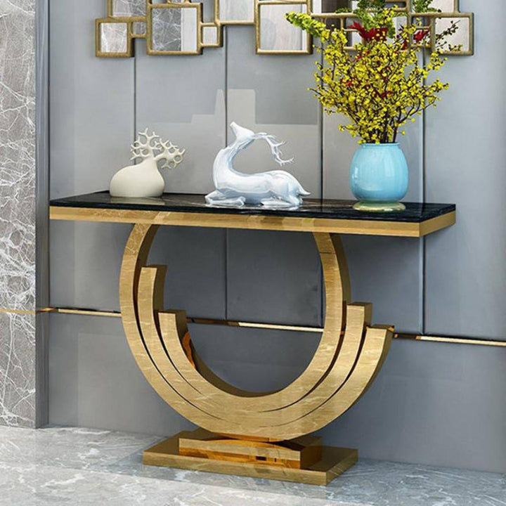 Front view of Lidia console table with black glass top and luxurious gold frame in an elegant interior setting