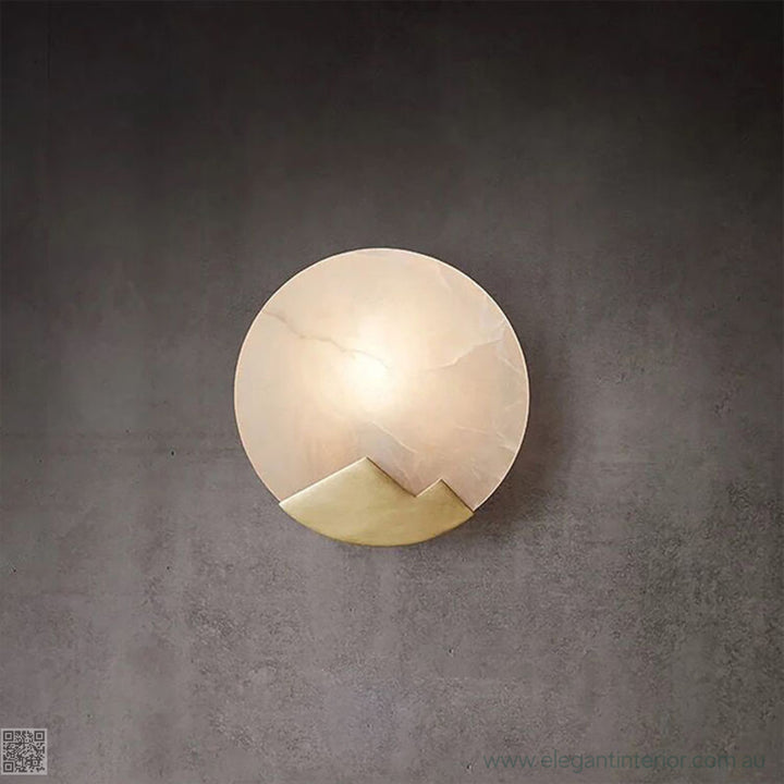 Marmar wall light front view with light on, showcasing warm glow and elegant marble design