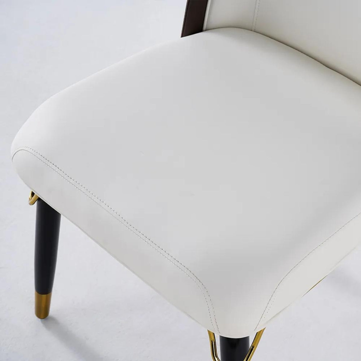 Close-up detail view of modern beige and black dining room chairs highlighting materials